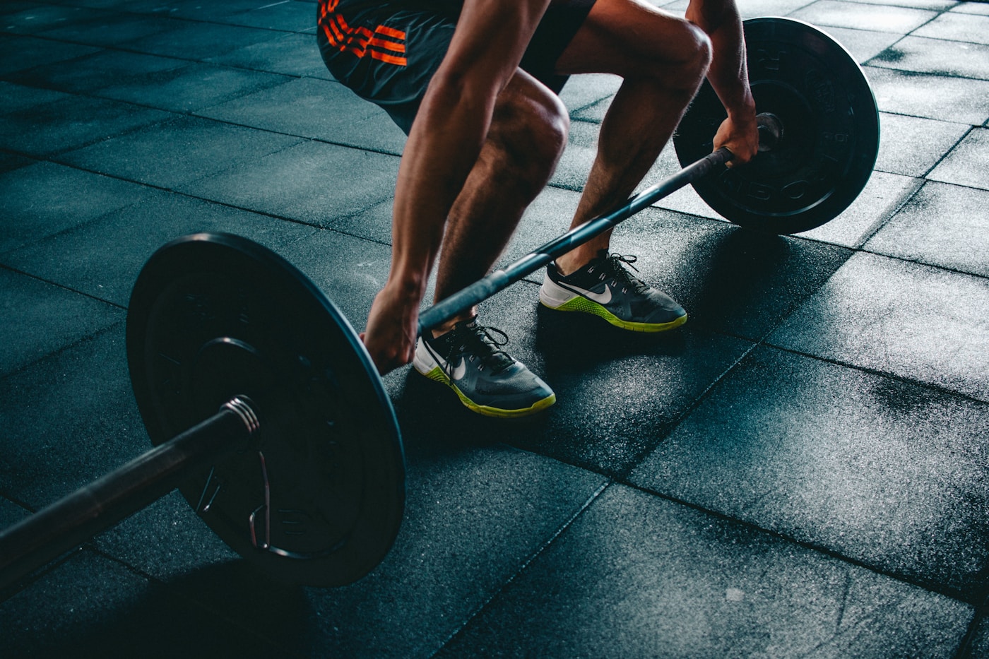 A close view of a strength training session with a barbell at a gym